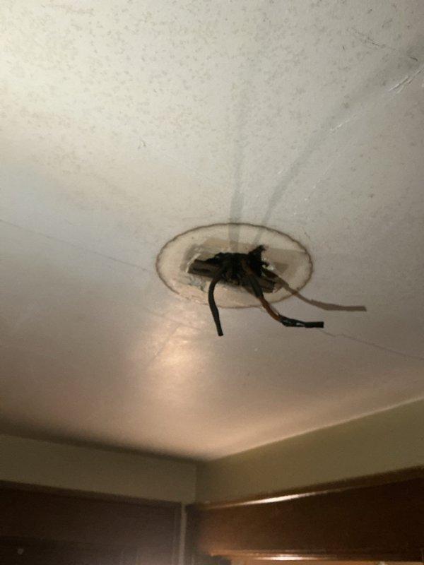 Replaced outdated stairway ceiling light fixture with new motion sensor-activated fixture in older residential property. Addressed safety concerns by securing deteriorated wire insulation and working with legacy wiring system that lacked modern electrical box infrastructure. Successfully installed recessed LED fixture with motion detection capability, ensuring proper electrical connections and code-compliant mounting despite non-standard ceiling configuration.