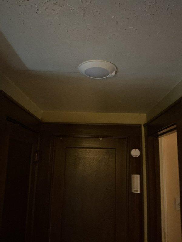 Replaced outdated stairway ceiling light fixture with new motion sensor-activated fixture in older residential property. Addressed safety concerns by securing deteriorated wire insulation and working with legacy wiring system that lacked modern electrical box infrastructure. Successfully installed recessed LED fixture with motion detection capability, ensuring proper electrical connections and code-compliant mounting despite non-standard ceiling configuration.