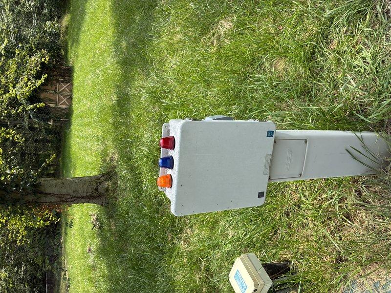 Uncovered electrical trench for required inspection after initial failed inspection. Exposed underground conduit and connections for inspector verification, with electrical panel and outdoor installation prepared for regulatory compliance review.