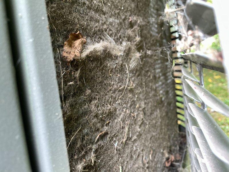 Responded to service call for 13-year-old air conditioning system experiencing short cycling every 20 seconds and failure to reach thermostat setpoint. Upon arrival, found condenser unit exterior heavily covered with dirt, organic debris, and biological growth indicating extended period without maintenance. Performed thorough cleaning of condenser coils and exterior surfaces to restore proper airflow and heat transfer efficiency. Addressed accumulated debris that was restricting airflow and causing unit to overheat and cycle prematurely. System tested after cleaning and confirmed proper operation with normal run cycles and adequate cooling to thermostat setpoint.