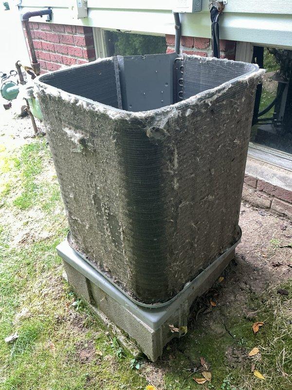 Responded to service call for 13-year-old air conditioning system experiencing short cycling every 20 seconds and failure to reach thermostat setpoint. Upon arrival, found condenser unit exterior heavily covered with dirt, organic debris, and biological growth indicating extended period without maintenance. Performed thorough cleaning of condenser coils and exterior surfaces to restore proper airflow and heat transfer efficiency. Addressed accumulated debris that was restricting airflow and causing unit to overheat and cycle prematurely. System tested after cleaning and confirmed proper operation with normal run cycles and adequate cooling to thermostat setpoint.