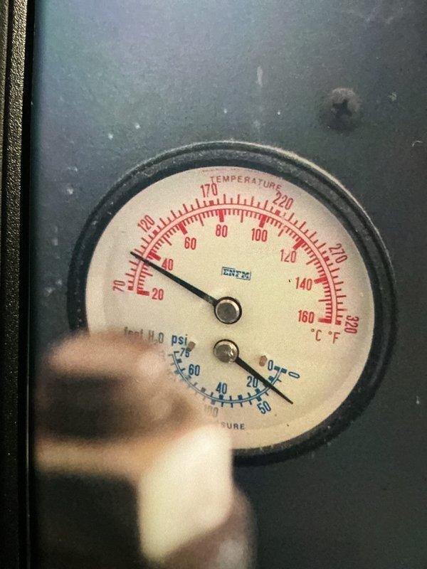 Completed MVP furnace maintenance inspection and system evaluation. Documented water supply plumbing assembly with copper piping, brass fittings, and shutoff valves, confirming proper configuration and connections. Inspected temperature and pressure gauge readings on heating system, verifying operational parameters within normal range with temperature and PSI measurements displaying correctly on analog gauge face.