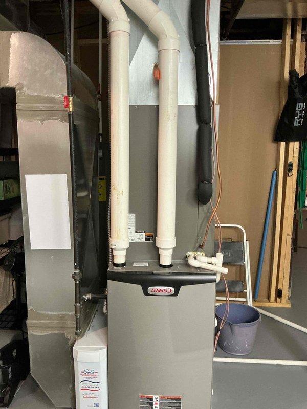 Completed MVP cooling maintenance visit on residential Lennox HVAC system located in basement utility area. Performed comprehensive inspection of furnace unit, verified proper operation of intake and exhaust venting through white PVC pipes, and checked all refrigerant lines and connections. Examined condensate pump operation and drainage system functionality. Inspected ductwork including flexible metal ducts and rectangular plenum connections for proper sealing and airflow. All system components operating within normal parameters with no issues identified during this recurring maintenance service.