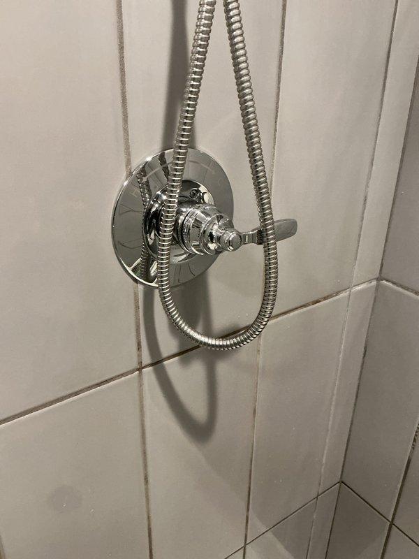 Replaced defective shower valve and installed new chrome trim assembly on tiled shower wall. Removed existing valve cartridge, installed replacement valve components, and completed finish work with polished chrome escutcheon plate and lever-style control handle. Tested system for proper operation and verified no leaks at connections.