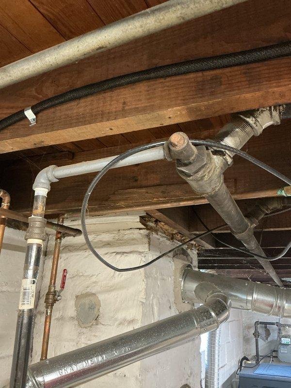 Conducted on-site evaluation of existing Bradford White Defender water heater system in basement utility area. Inspected 15.5-year-old conventional tank water heater showing visible signs of age including surface wear and exterior discoloration. Assessed all plumbing connections including copper supply lines, brass shut-off valves, and vent piping configuration. Examined condition of piping system noting natural oxidation and patina on copper components consistent with age of installation. Evaluated mechanical room layout and existing infrastructure to determine feasibility for both conventional tank replacement and tankless water heater conversion options. Documented current installation configuration including all connections, venting arrangements, and available utility access points. Photographed equipment and surrounding plumbing infrastructure to support estimate preparation. Prepared comprehensive pricing proposal covering both standard tank water heater replacement and alternati