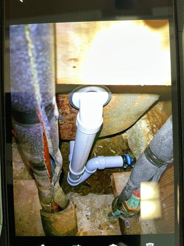 Replaced deteriorated waste and overflow assembly on bathtub due to severe corrosion and rot. Removed and replaced failed trap assembly showing significant rust damage and material degradation. Reconnected drainage system to existing copper exit drain serving toilet using new PVC fittings and components. Addressed moisture damage and corrosion evident on subfloor and surrounding plumbing infrastructure. Work required accessing plumbing through ceiling/wall cavity to complete proper installation and ensure secure connections throughout the drainage system.