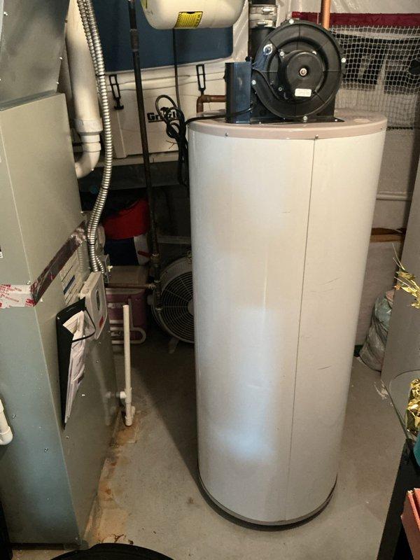 Responded to service call for water heater experiencing a small leak and pinging noise. Upon inspection, identified the source of the leak at the temperature and pressure relief valve and addressed minor sediment accumulation causing the audible pinging. Examined the natural gas water heater unit, which showed previous maintenance records from 2010 including T&P valve and expansion tank replacement. Verified all plumbing connections, tested safety systems, and confirmed proper operation of the heating element and thermostat controls. Documented existing equipment configuration including HVAC system proximity and utility room conditions for future reference.