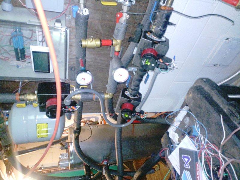 Responded to service call for furnace leaking issue on unit installed in March. Upon inspection, identified leak in furnace system and photographed installation showing HVAC components including pressure gauges, expansion tank, refrigerant lines, and associated mechanical connections. Documented PCB-related concerns and overall system configuration for further evaluation and repair recommendations.