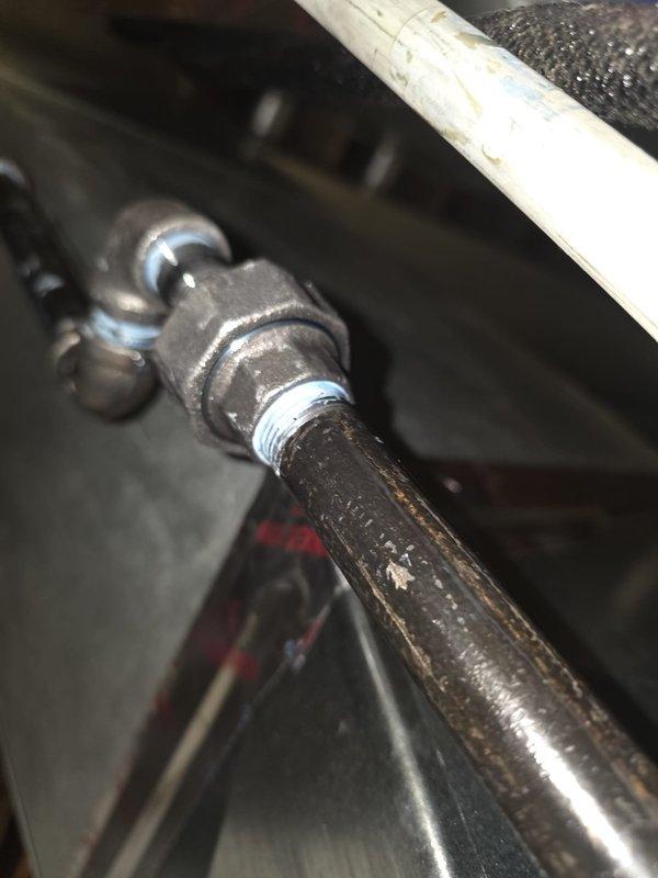 Responded to failed inspection due to active gas leak detected at pipe union connection. Shut off gas supply to equipment for safety. Documented corroded and deteriorated threaded union connection showing visible wear and surface degradation. Equipment remains offline pending repair of gas leak at union fitting.