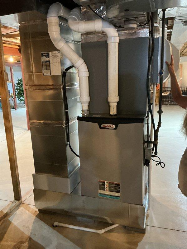 Completed scheduled MVP cooling maintenance visit on Lennox outdoor condensing unit and indoor air handling system. Performed comprehensive system inspection including visual assessment of outdoor unit positioned on concrete pad against building exterior, verified proper clearances and drainage through white PVC condensate line, and inspected indoor furnace/air handler with associated ductwork and electrical connections. All components operating within normal parameters with no immediate service needs identified. System ready for continued cooling season operation.