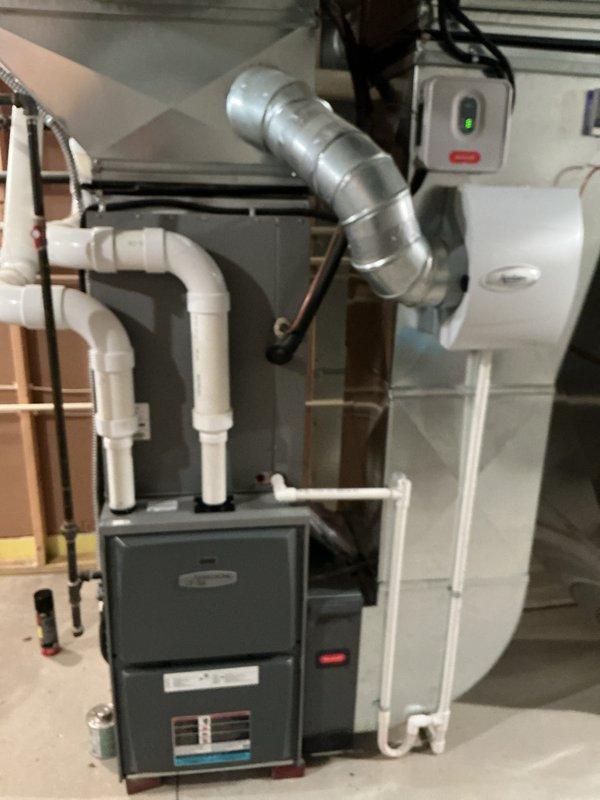 Completed full HVAC system installation consisting of two 90% efficiency furnaces and two air conditioning units in residential basement utility space. Installation included proper mounting of furnace units, connection of metallic supply ductwork with appropriate transitions and elbows, installation of white PVC condensate drain lines with multiple fittings to ensure proper drainage, and routing of copper refrigerant linesets between indoor and outdoor components. All electrical connections completed including dedicated disconnect switches with indicator lights, system controls wired and tested for proper operation. Verified proper clearances around equipment, secured all piping and refrigerant lines, and confirmed both heating and cooling systems operational upon completion.