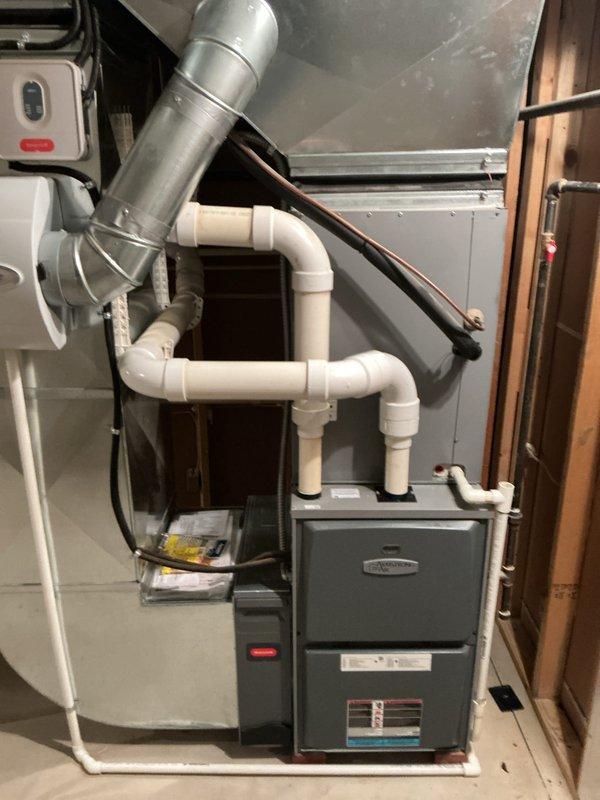 Completed full HVAC system installation consisting of two 90% efficiency furnaces and two air conditioning units in residential basement utility space. Installation included proper mounting of furnace units, connection of metallic supply ductwork with appropriate transitions and elbows, installation of white PVC condensate drain lines with multiple fittings to ensure proper drainage, and routing of copper refrigerant linesets between indoor and outdoor components. All electrical connections completed including dedicated disconnect switches with indicator lights, system controls wired and tested for proper operation. Verified proper clearances around equipment, secured all piping and refrigerant lines, and confirmed both heating and cooling systems operational upon completion.