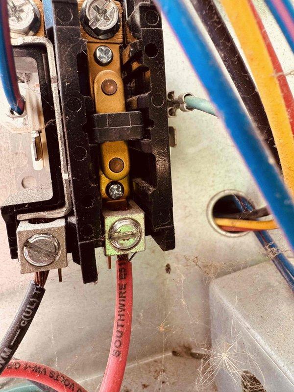 Responded to no cooling complaint on 3-year-old air conditioning system blowing warm air. Upon inspection, discovered multiple electrical connection issues at terminal block, including corroded and oxidized brass terminals with visible green patina. Performed voltage testing using digital multimeter to verify electrical integrity of connections. Found improper wiring connections that compromised system performance. Cleaned corroded terminals, tightened all electrical connections, and verified proper voltage readings throughout the system. Educated homeowner on importance of regular professional maintenance beyond filter changes for self-installed equipment. System restored to proper cooling operation.