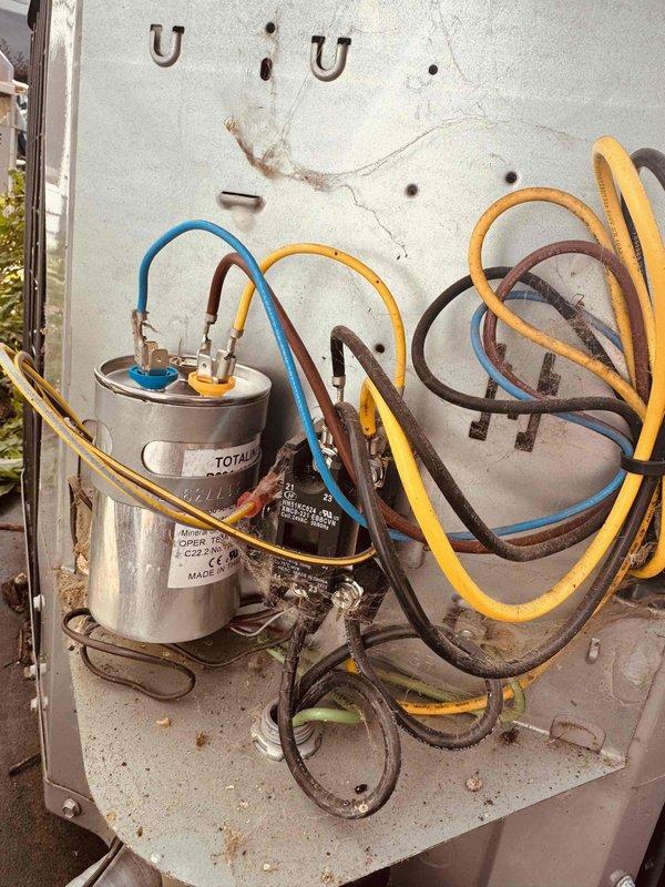 # HVAC Service Report

Responded to no-cooling complaint on 7-year-old residential air conditioning system with reported buzzing noise from outdoor unit. Upon inspection, identified failed dual-run capacitor as root cause of compressor malfunction and abnormal sound. Capacitor tested at 893 microfarads, significantly outside manufacturer specifications of 30 microfarads indicated on component label. Removed defective capacitor showing visible signs of age deterioration, corrosion on terminals, and compromised mounting hardware. Installed new OEM-equivalent dual-run capacitor with proper ratings for compressor and condenser fan motor. Verified electrical connections, secured all wiring, and tested system operation. Unit now cooling properly with normal amperage draw and no abnormal sounds. System returned to full operational status.