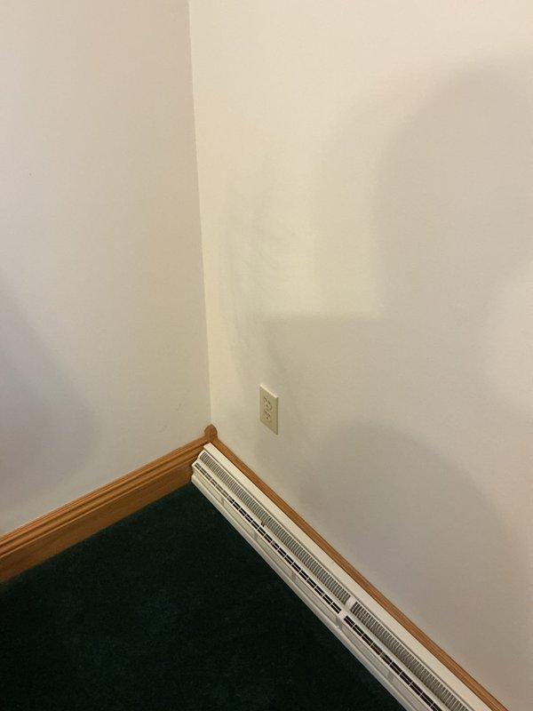 Installed dedicated electrical outlet for stairlift operation in residential interior corner location. Outlet was mounted on wall above baseboard molding to provide accessible power supply for mobility equipment, with installation completed after 10 AM per customer notification timing.