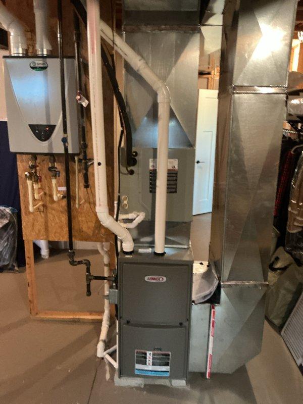 Completed installation of new air conditioning system with evaporator coil in residential basement mechanical room. Installed new A-frame evaporator coil on existing Lennox furnace, connected refrigerant lines, and integrated with new sheet metal ductwork system featuring vertical supply plenum with proper transitions. Verified all connections, tested system operation, and ensured proper airflow throughout the distribution system.