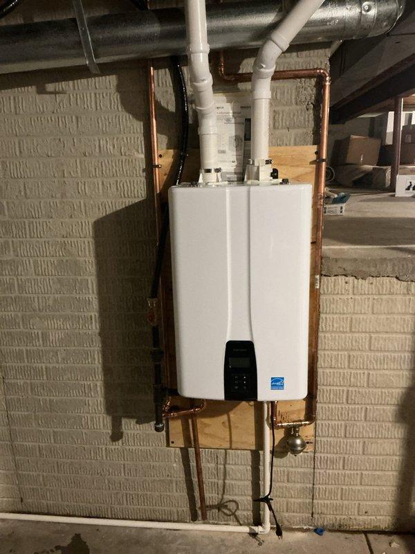 Replaced a leaking 40-gallon tall water heater with a new Navien NPE-240A2 tankless water heater. Mounted the unit near the crawl space access opening for improved accessibility. Installed copper supply piping on both sides of the unit and routed PVC condensate drain line to existing floor drain behind furnace. Ran PVC exhaust and fresh air intake piping through crawl space to west exterior wall with proper termination and vent caps. Coordinated electrical outlet installation to provide dedicated power supply for tankless unit. All necessary parts were pre-staged prior to installation to ensure efficient completion of the retrofit.