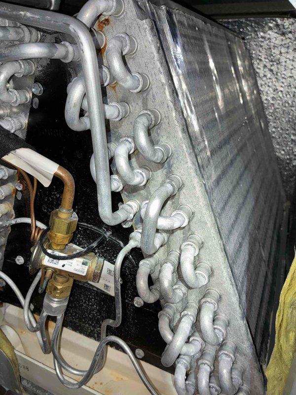 Completed comprehensive AC tune-up for new homeowner with unknown service history on Trane system. Performed full inspection of evaporator coil assembly, verified refrigerant line connections showing minor surface oxidation but structurally sound, and tested brass valve assembly with condensate management system for proper operation. All components found to be in functional condition with normal operational wear; system operating within manufacturer specifications with no immediate service needs identified.