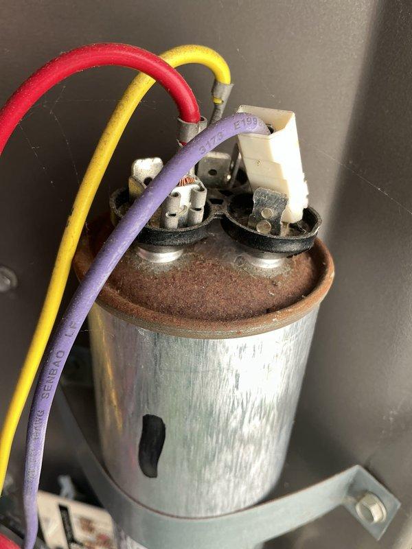 Responded to no cooling call on 6-year-old heat pump system with indoor temperature at 82 degrees. Upon inspection, found outdoor unit fan running but compressor not operating. Diagnosed failed dual run capacitor showing visible signs of corrosion and rust on terminal connections. Replaced defective capacitor with new unit, verified proper microfarad ratings, and tested system operation. Unit now cooling properly with compressor and condenser fan motor operating within normal parameters.