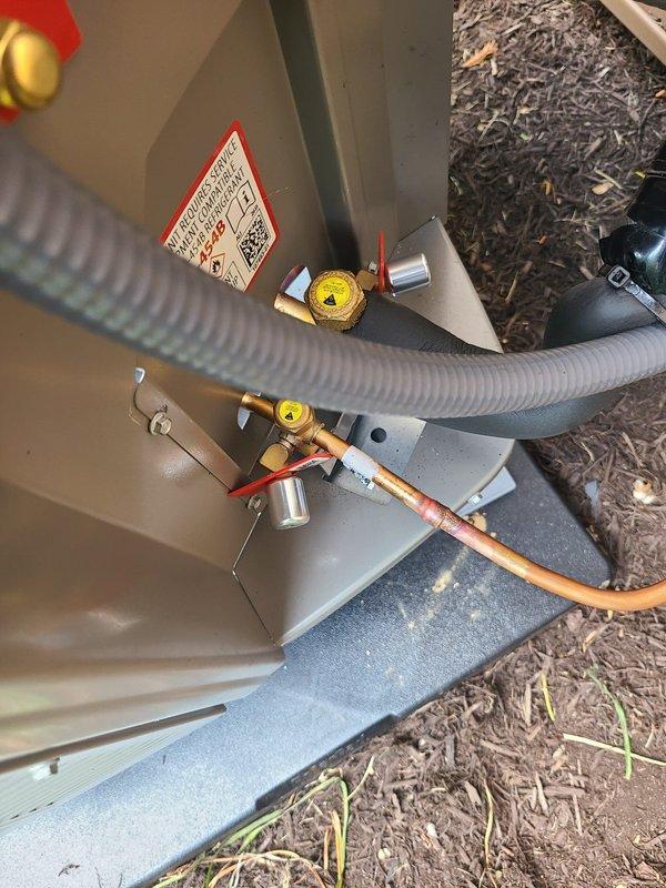 Completed installation of smaller dual-zone heat pump system including outdoor condenser unit and indoor air handler. Installed 20-amp FLNR fuses in disconnect box, positioned outdoor unit on concrete pad with proper refrigerant line connections and service valves, and verified all electrical connections meet code requirements.