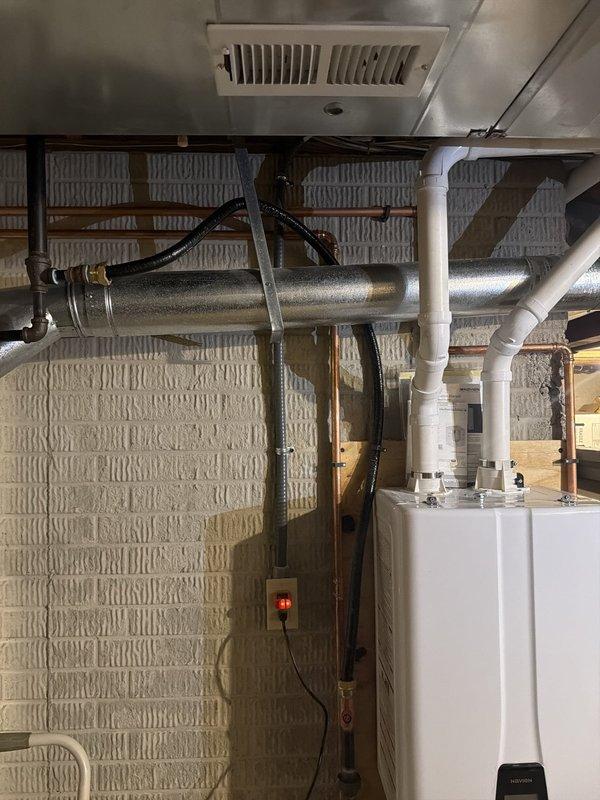 Installed dedicated electrical outlet for tankless water heater in utility area. Ran new circuit wiring through basement space to power unit, ensuring proper amperage and code compliance for the tankless water heating system.