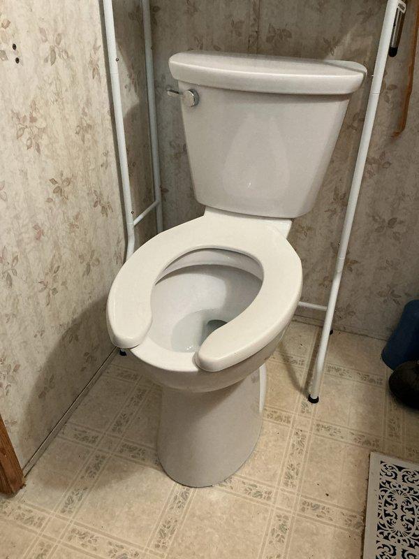 Removed existing toilet from master bathroom and installed new American Standard Cadet Pro extra tall elongated toilet with special open end seat. Replaced wax ring, mounting bolts, and supply line to ensure proper seal and water connection. Completed installation in approximately three hours with all components functioning properly.