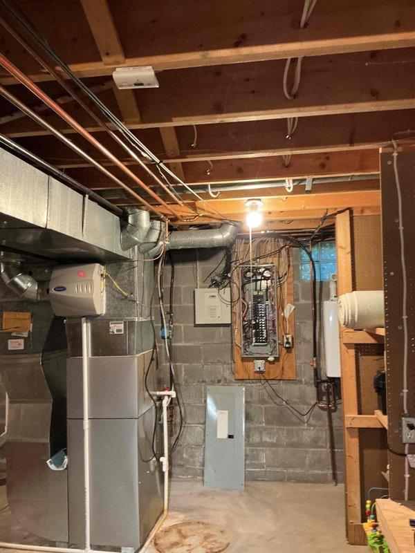Conducted electrical estimate for residential backup generator installation at unfinished basement location. Assessed existing electrical infrastructure including main breaker panel, available circuit capacity, and optimal transfer switch placement. Documented current electrical system configuration with panel mounted on concrete block wall, noting proximity to HVAC furnace, water heater, and existing utility connections. Evaluated conduit routing options from proposed generator location to transfer switch and main electrical panel. Photographed electrical panel layout showing circuit breaker arrangement and existing wire runs to determine load calculations and transfer switch sizing requirements. Assessed adequate clearances for code-compliant generator installation considering existing mechanical equipment and utility infrastructure. Provided comprehensive documentation for generator system proposal including electrical service capacity verification and installation scope.