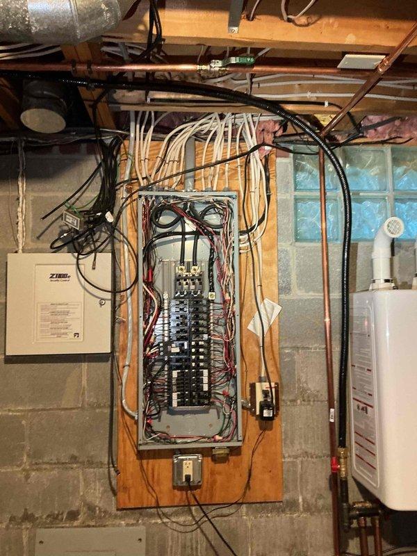 Conducted electrical estimate for residential backup generator installation at unfinished basement location. Assessed existing electrical infrastructure including main breaker panel, available circuit capacity, and optimal transfer switch placement. Documented current electrical system configuration with panel mounted on concrete block wall, noting proximity to HVAC furnace, water heater, and existing utility connections. Evaluated conduit routing options from proposed generator location to transfer switch and main electrical panel. Photographed electrical panel layout showing circuit breaker arrangement and existing wire runs to determine load calculations and transfer switch sizing requirements. Assessed adequate clearances for code-compliant generator installation considering existing mechanical equipment and utility infrastructure. Provided comprehensive documentation for generator system proposal including electrical service capacity verification and installation scope.