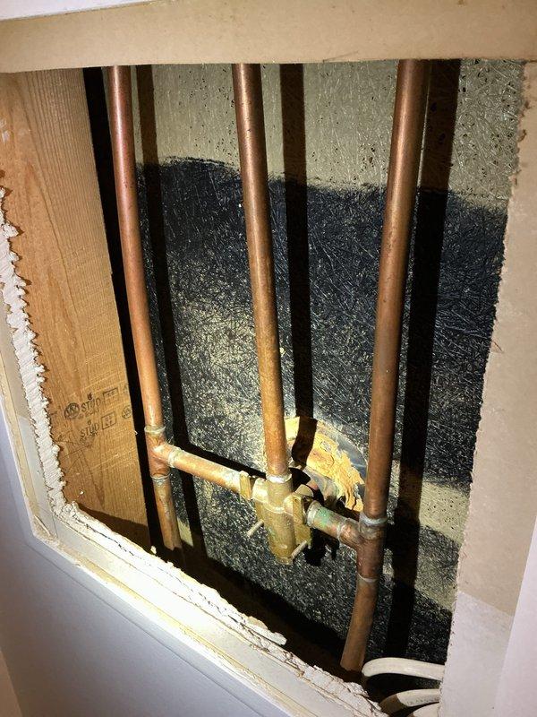 Replaced a dripping Delta shower faucet with a new Moen Chateau shower faucet assembly. Accessed the plumbing through an existing access panel, which required enlargement at the bottom for proper clearance. Installed new shut-off valves along with necessary copper pipe and brass fittings to complete the installation. All connections were secured and tested for proper operation and leak-free performance.