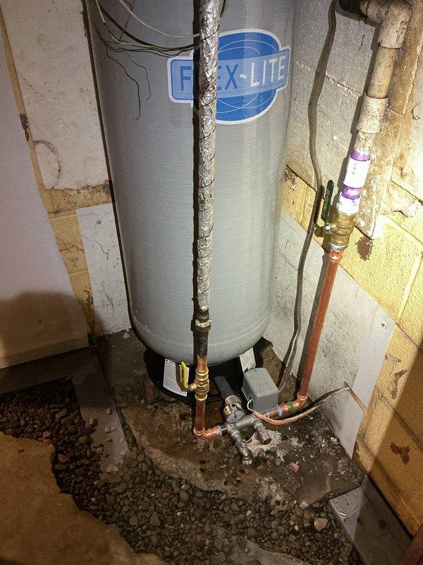 Replaced existing pressure tank with new 30-gallon FLEX-LITE pressure tank. Installation included new pressure switch, tee fitting, pressure gauge, drain valve, and relief valve. Installed new shut-off valve on threaded PVC supply line upstream of tank. All copper pipe connections completed with brass fittings and properly secured. System tested and verified operational upon completion.