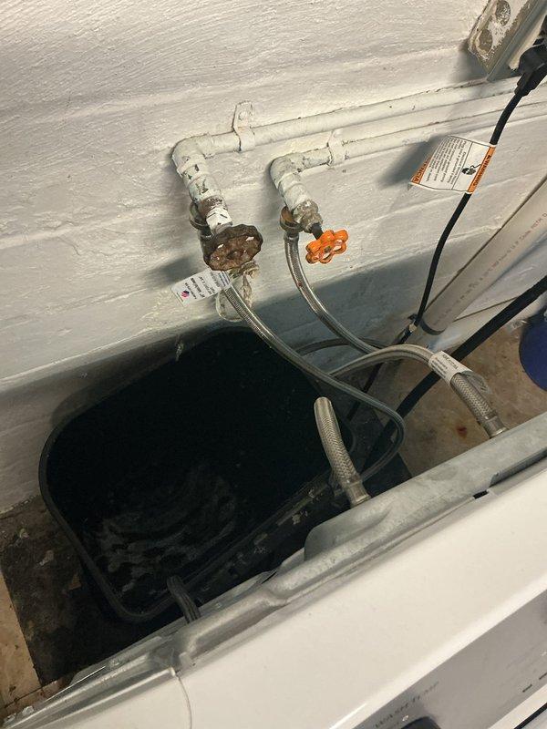 Installed new ball valve with orange handle on water supply line in basement utility area. Replaced existing valve assembly and connected braided stainless steel flexible supply hoses to ensure proper water flow control. System tested and verified operational with no leaks detected.