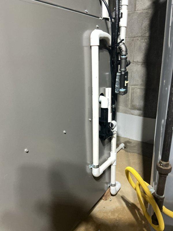 Completed installation of a 90% efficiency furnace and air conditioning system. Installed new electrical disconnect with FLNR 35 amp fuses rated at 250 volts, established proper electrical connections with color-coded wiring, and mounted outdoor condensing unit. Inside mechanical room, installed furnace unit with associated PVC condensate drainage system featuring multiple drain lines and proper pitch for water removal. Routed black flexible electrical conduit for system controls and power supply, installed safety float switch on drainage system, and established all necessary connections to existing ductwork. System tested and verified operational with all safety devices functioning properly.