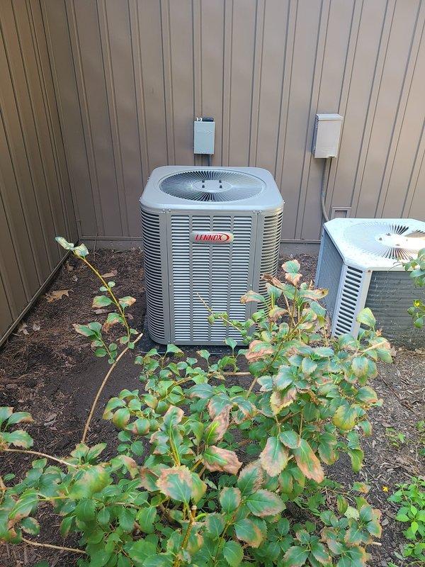 Completed full HVAC system installation including new Lennox air conditioning condenser unit and evaporator coil in open, walkable attic space. Installed outdoor condenser unit on exterior wall with proper clearances, established refrigerant line set routing through side passage using insulated copper lines with protective gray conduit, and mounted electrical disconnect box with appropriate safety components. System commissioned and tested for proper operation with all connections secured and insulated per manufacturer specifications.