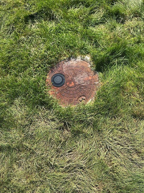 Responded to natural gas leak call near meter vault. Upon arrival, located circular brick-paved meter vault access point in front lawn area. Conducted thorough leak detection survey using appropriate gas detection equipment. Marked underground utility lines with red safety flags to establish work zone and ensure safe excavation parameters. Identified leak source at service connection point adjacent to meter vault assembly. Verified leak location and documented conditions with photographic evidence showing meter vault installation and marked utility corridor. Completed initial assessment and prepared site for repair procedures while maintaining safety protocols for natural gas service work.