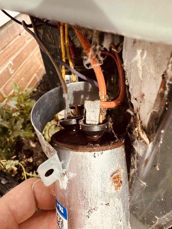 Responded to service call for 16-year-old Trane central air conditioning system that had lost cooling capacity and was only producing temperate air. Upon inspection, found dual critical issues: severely deteriorated dual-run capacitor showing extensive rust, corrosion, and weather damage with compromised connections, and evaporator coils heavily caked with dust and debris accumulation restricting airflow. Replaced failed capacitor with new OEM-equivalent component and performed thorough coil cleaning to remove thick layer of contamination. Restored proper electrical values, verified adequate airflow across coils, and tested system operation with satisfactory cooling performance and temperature differential.