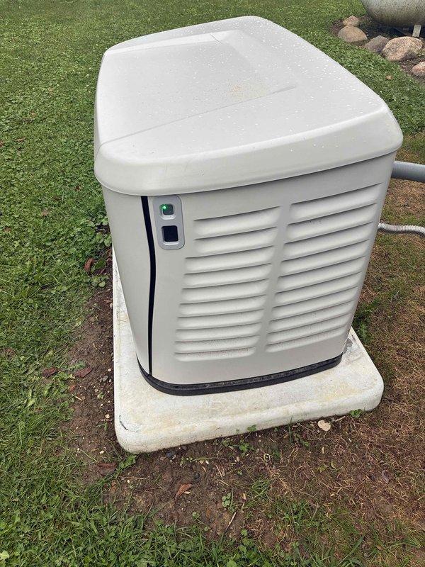 Performed comprehensive generator walkthrough and system inspection at residential property. Documented standby generator unit installed on concrete pad, verified housing condition and operational indicator lights, and photographed exterior components including PVC exhaust/intake piping mounted to home foundation with proper brackets and connections. Generator system appears properly installed with adequate ventilation clearances and secure mounting.