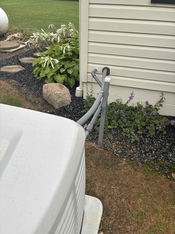 Performed comprehensive generator walkthrough and system inspection at residential property. Documented standby generator unit installed on concrete pad, verified housing condition and operational indicator lights, and photographed exterior components including PVC exhaust/intake piping mounted to home foundation with proper brackets and connections. Generator system appears properly installed with adequate ventilation clearances and secure mounting.