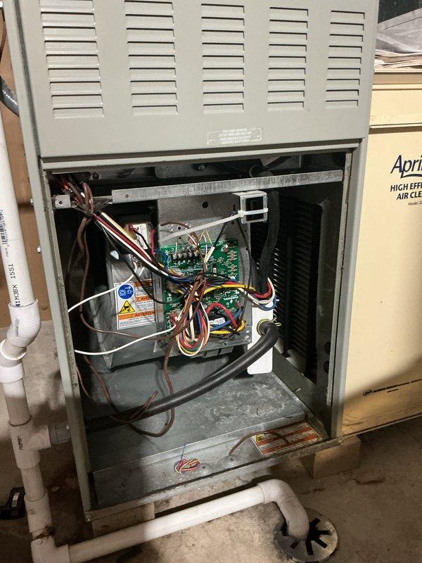 # HVAC Service Report

Responded to no cooling complaint on 2-year-old air conditioning system. Performed diagnostic inspection of indoor air handler unit. Removed access panel and inspected internal components including control boards, wiring connections, and electrical systems. Examined circuit boards, wire bundles, and connection points for signs of failure or malfunction. Inspected condensate drain piping and mechanical components within the unit. All findings documented with photographs for service records.