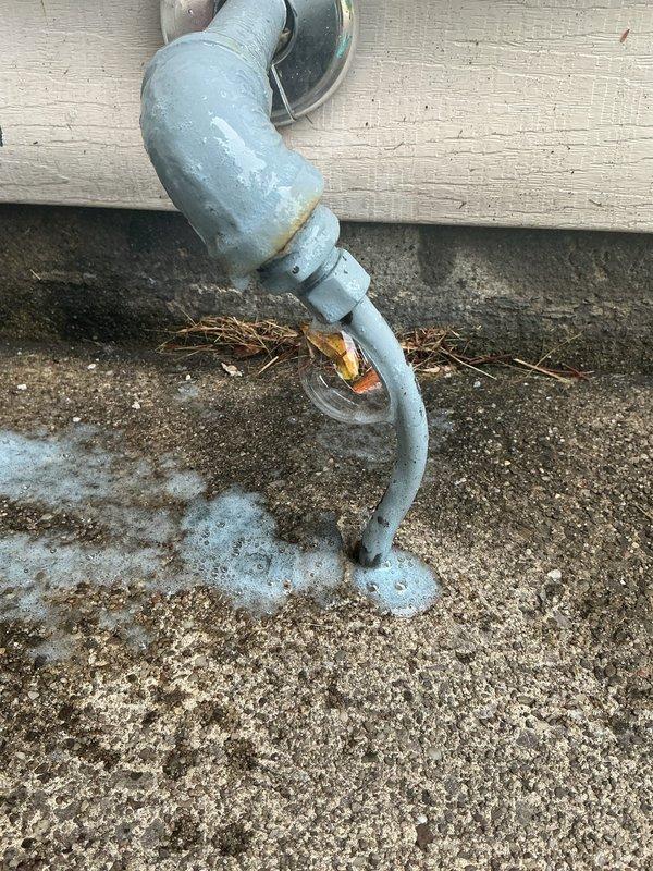 Responded to gas leak on exterior gas line. Located leak at threaded connection point on galvanized pipe assembly mounted to building exterior. Applied leak detection solution to confirm active leak at joint. Tightened and re-sealed threaded fitting to eliminate gas escape. Performed pressure test to verify repair integrity and confirm no additional leaks present in exposed piping. Additionally secured loose toilet inside residence by tightening closet bolts and reseating fixture to floor flange.