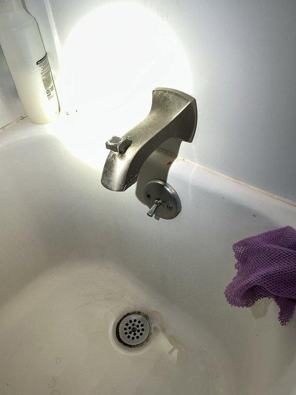 Responded to service call for clogged bathtub drain. Upon arrival, found drain obstructed with visible signs of buildup and reduced water flow. Removed drain cover and cleared blockage using appropriate drain cleaning tools. Inspected faucet assembly and noted significant mineral deposits on chrome fixtures. Tested drain flow after clearing obstruction to ensure proper drainage was restored. Completed work and verified bathtub draining properly.