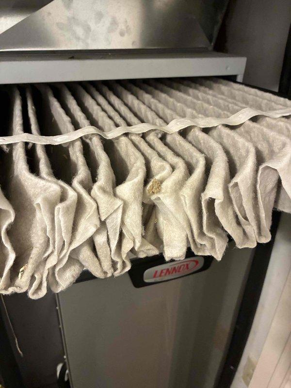 Completed MVP air conditioning maintenance service on residential Lennox cooling system. Inspected outdoor condenser unit and found normal operating conditions with minor debris accumulation from seasonal leaf fall. Discovered heavily soiled and deformed air filter exhibiting significant sagging and particulate buildup, indicating restricted airflow and reduced system efficiency. Replaced failed filter to restore proper air circulation and system performance.