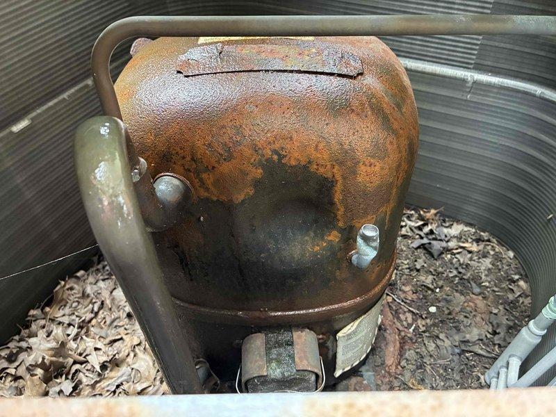Completed MVP cooling maintenance on outdoor AC unit. Inspected and documented dual-element 40-amp FRN-R fuses in disconnect, which were functional but showing age-related discoloration. Found significant rust and corrosion on air handler components with accumulated debris including leaves and organic matter inside ductwork, indicating moisture intrusion and potential drainage issues requiring future attention.