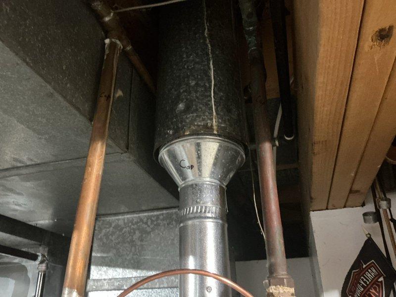 Responded to service call for leaking 6-year-old tanked water heater with water seepage from bottom of unit. Performed on-site assessment of existing water heater installation and documented current conditions with photos. Inspected water heater location, venting system, gas connections, and surrounding plumbing infrastructure in unfinished basement area. Evaluated existing ductwork, copper supply lines, and structural mounting configuration. Provided quote for complete water heater replacement with new tanked unit and discussed alternative tankless water heater options per customer interest.