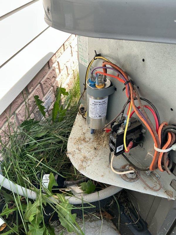 # HVAC Service Report

Responded to no cooling complaint at manufactured home. Upon inspection, found outdoor condensing unit operational but system not producing adequate cooling. Accessed electrical compartment and identified failed dual run capacitor as root cause. Capacitor tested below acceptable microfarad range, preventing compressor from starting properly. Removed defective capacitor and installed new replacement unit with correct specifications. Verified all electrical connections secure and properly terminated. Cleared vegetation growth around unit that had accumulated near base and electrical components. Tested system operation after repair - compressor engaged properly, unit cycling normally, and cold air restored to living space. System returned to full cooling capacity.