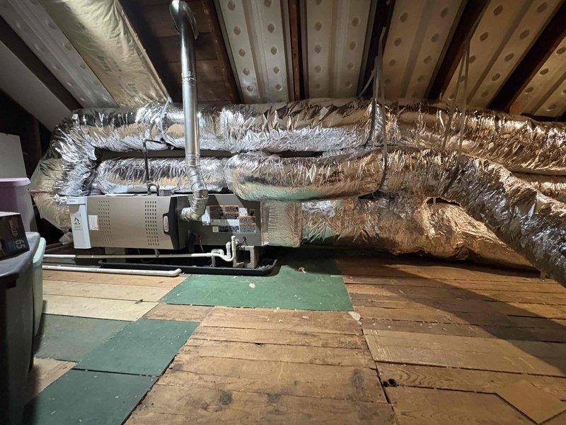 Returned to site to address furnace door installation issue and complete return air ductwork installation. Successfully secured furnace access door to ensure proper seal and safe operation of the air handler unit. Installed additional flexible return air ducts to optimize airflow distribution throughout the attic-mounted HVAC system, connecting to the beige air handler unit mounted on platform. All ductwork properly wrapped in reflective insulation and secured according to manufacturer specifications and code requirements.