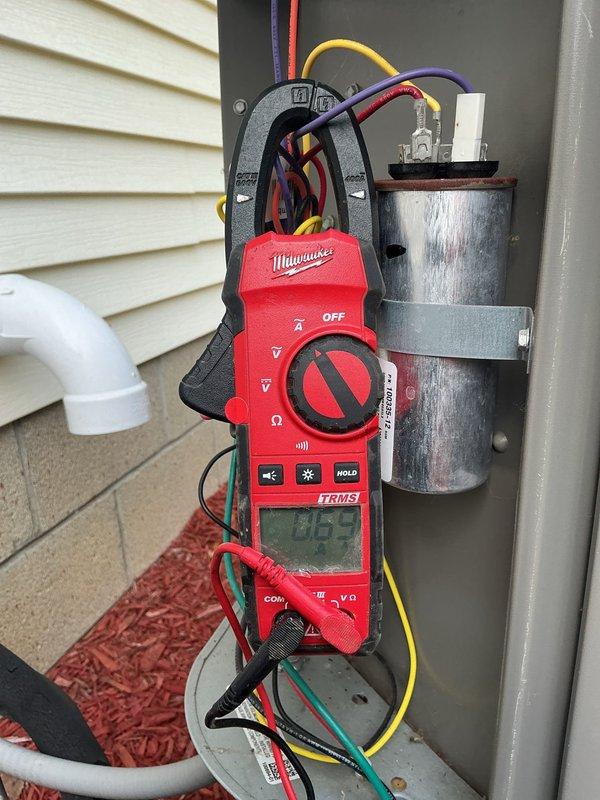 Completed comprehensive MVP heating and cooling maintenance visit on residential HVAC system. Performed electrical diagnostics on outdoor unit using TRMS clamp meter, measuring amperage draw and testing capacitor functionality—readings indicated normal operation at 0.05 amps with some visible wear on capacitor surface noted. Inspected and verified clean Aprilaire pleated air filter in proper working condition within air handler unit.