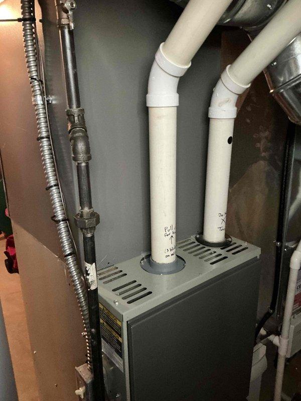 Conducted furnace inspection and identified cracks in the heat exchanger of a 19-year-old unit. Provided replacement estimate and documented existing HVAC equipment including air handler, ductwork, and associated PVC venting system with photographic evidence.