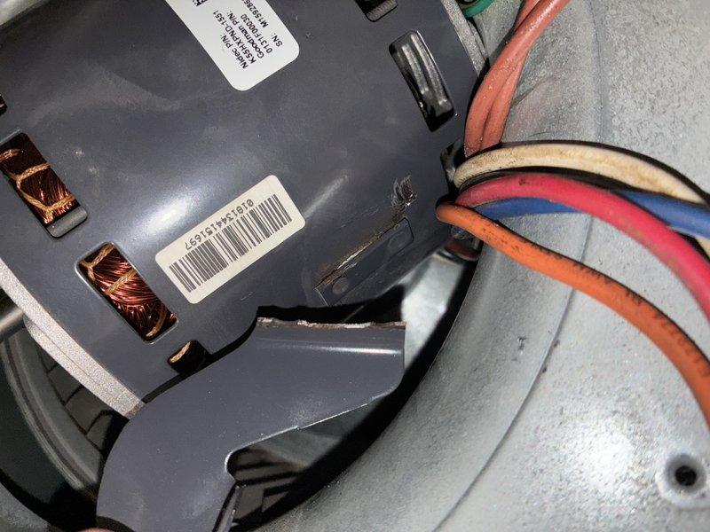 Responded to service call for loud noise coming from HVAC blower motor in 10-year-old furnace unit located in basement. Upon inspection, discovered significant crack in blower motor housing and exposed copper windings indicating motor failure. Documented damage with photographs showing compromised motor casing, visible electrical connections, and wire assembly. Diagnosed failed blower motor as source of reported noise and recommended replacement to restore proper system operation.