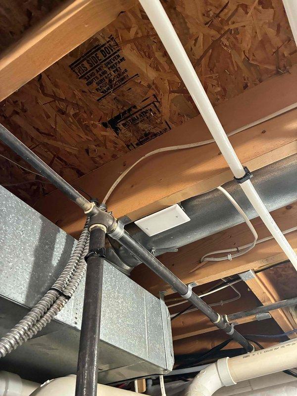 Installed dedicated electrical circuit for tankless water heater installation. Ran new wiring through unfinished ceiling space, routing cable through floor joists and coordinating placement around existing plumbing, HVAC ductwork, and structural members. Secured all conductors per code requirements and completed rough-in wiring in preparation for final connections.