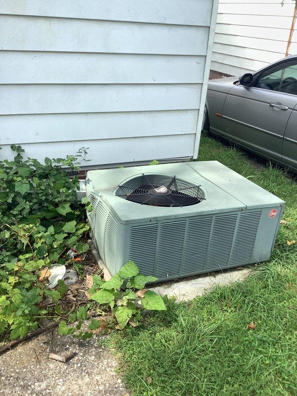 Responded to storm damage assessment for residential air conditioning condenser unit impacted by fallen gutters. Conducted on-site inspection and documented exterior damage to outdoor condensing unit with photographic evidence. The older model AC unit showed weathering and potential structural compromise from gutter impact, requiring full system evaluation to determine repair versus replacement recommendation for homeowner.